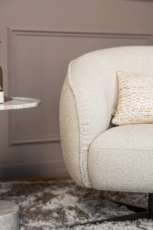 Lio armchair with a curved silhouette and soft upholstery, designed for modern and elegant living interiors.