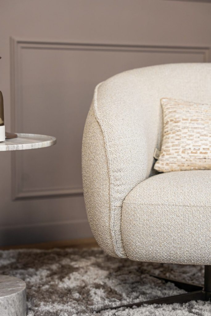 Lio armchair with a curved silhouette and soft upholstery, designed for modern and elegant living interiors.